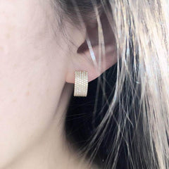 wide diamond huggies on ear