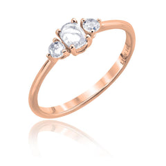 three rose cut diamonds on a rose gold band. Center stone is oval, and 2 round side stones