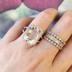 Bezel set diamond eternity band stacked with other rings